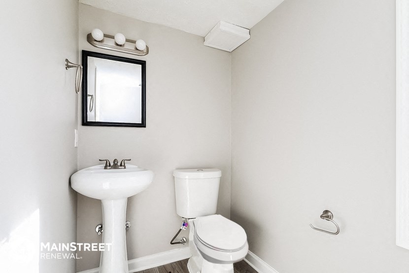a small bathroom with a sink toilet and mirror