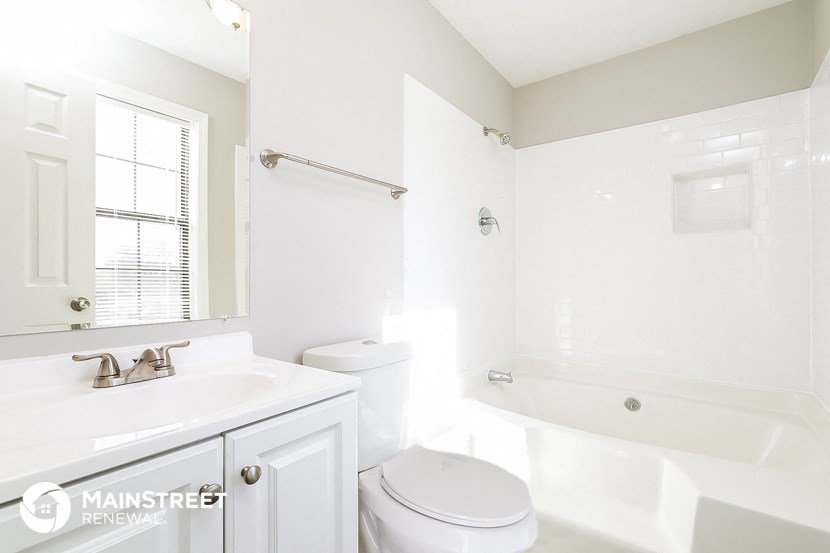 a white bathroom with a toilet and a tub and a sink