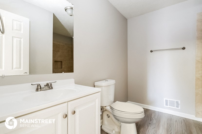 a bathroom with a toilet and a sink and a mirror