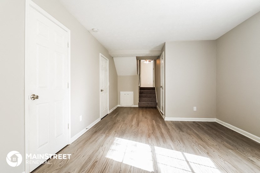 a renovated living room with hardwood floors and white walls
