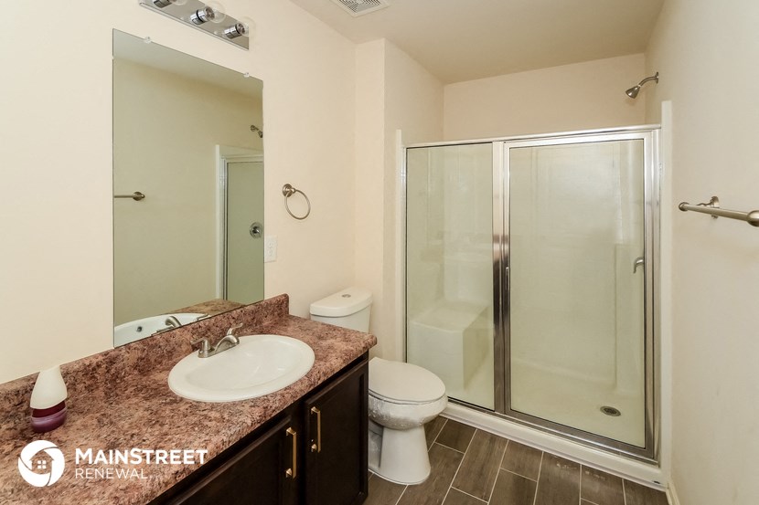 a bathroom with a shower and a sink and a toilet