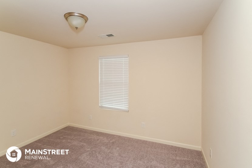 the upstairs bedroom with carpeted flooring and a window