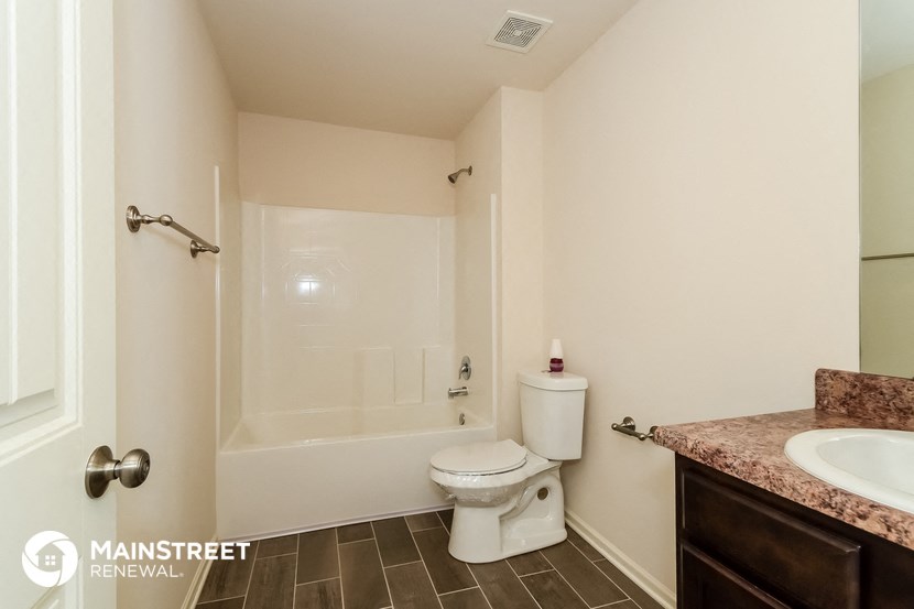 a bathroom with a toilet and a tub and a sink