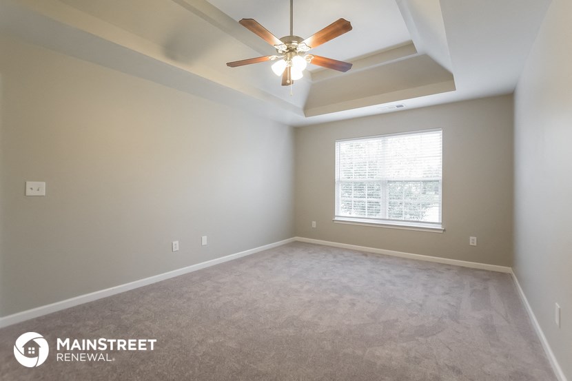 an empty room with a ceiling fan and a window