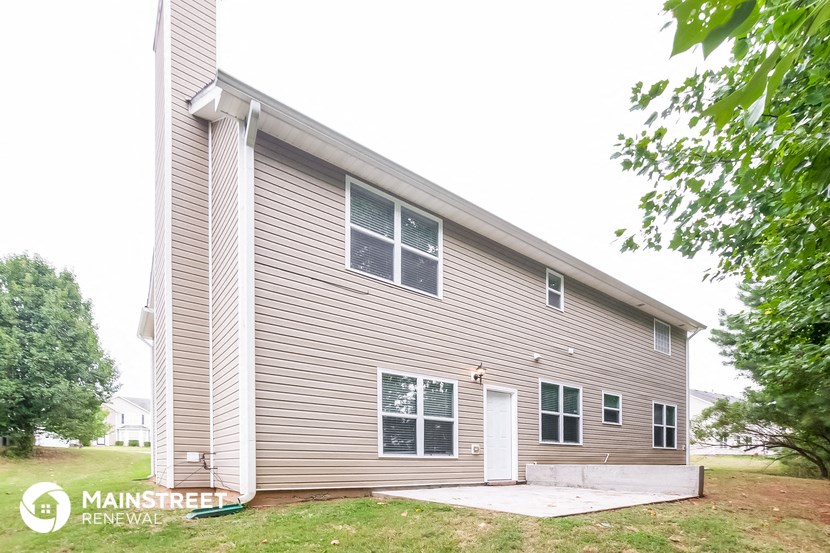 the front of a house with a porch and a white door