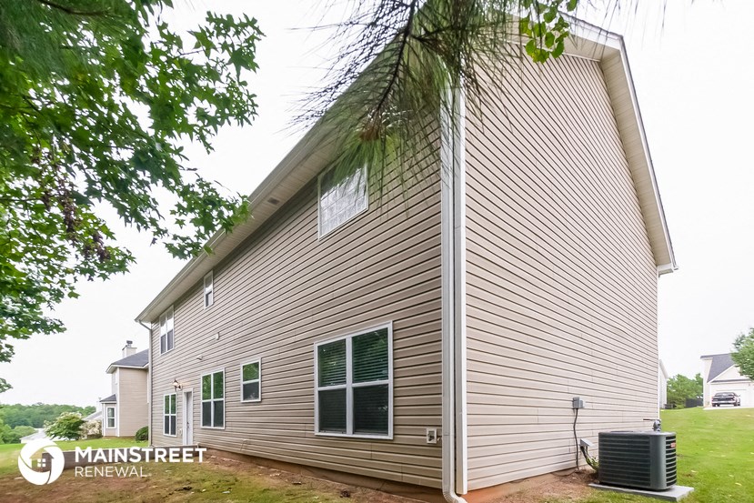 the side of a house with a tree in front of it