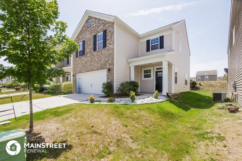 a white house with a garage and a lawn