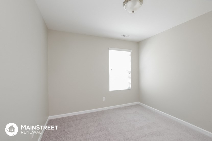 an empty room with white walls and a window