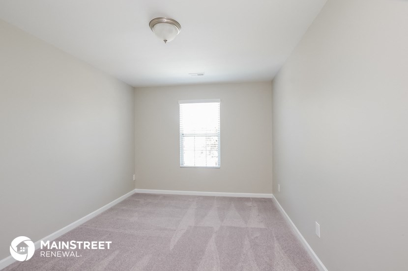 an empty room with a window and white walls