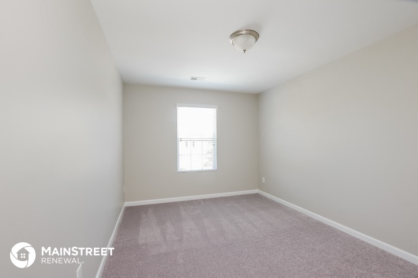 an empty room with white walls and a window