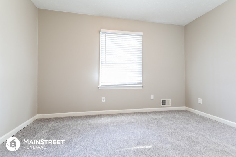 a room with a carpeted floor and a window