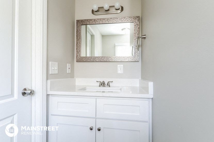 a white bathroom with a sink and a mirror