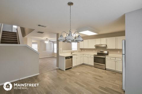 an open kitchen with white cabinets and stainless steel appliances