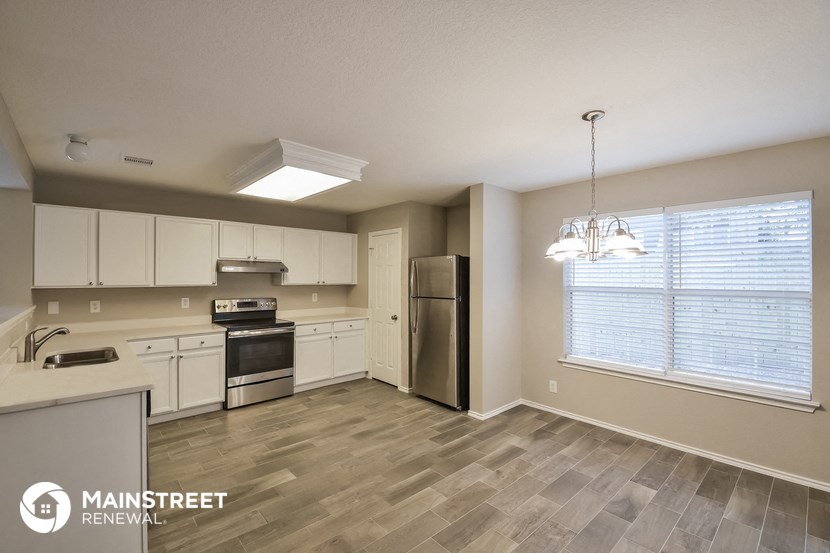 an empty kitchen with white cabinets and stainless steel appliances