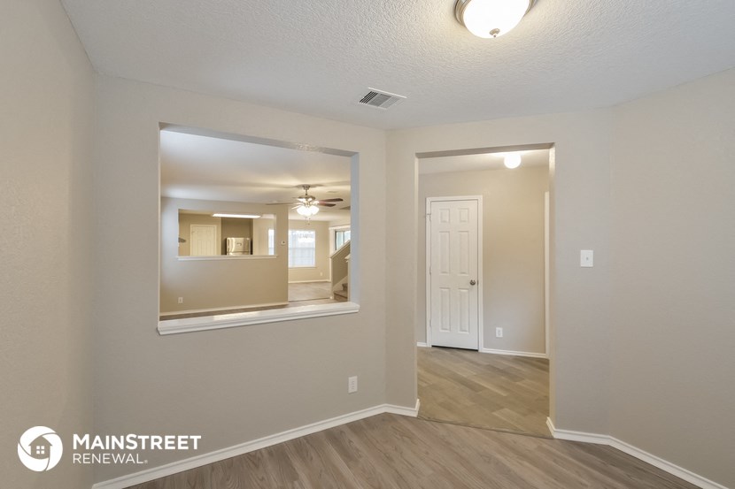 the living room and dining room of a manufactured home with a large mirror