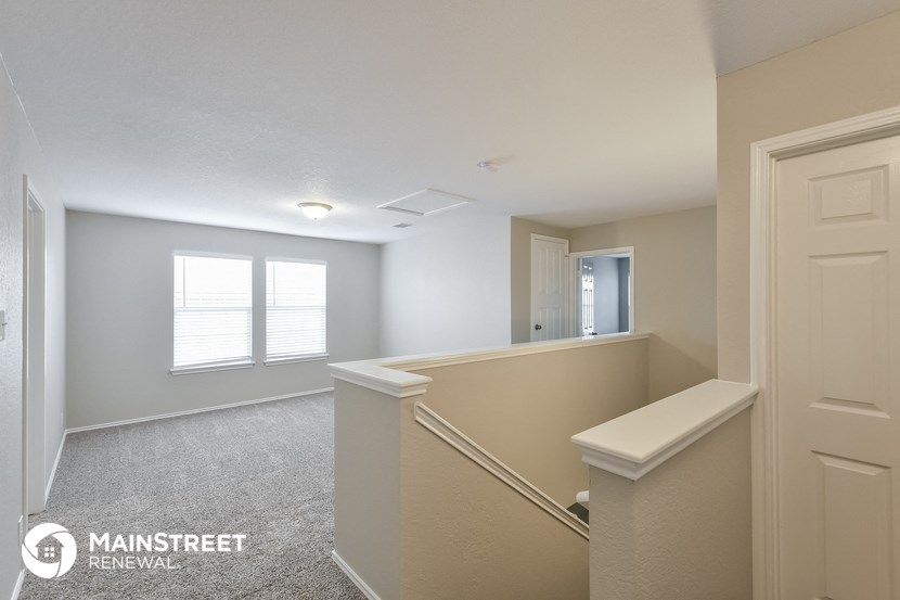 a large white room with a staircase and a window