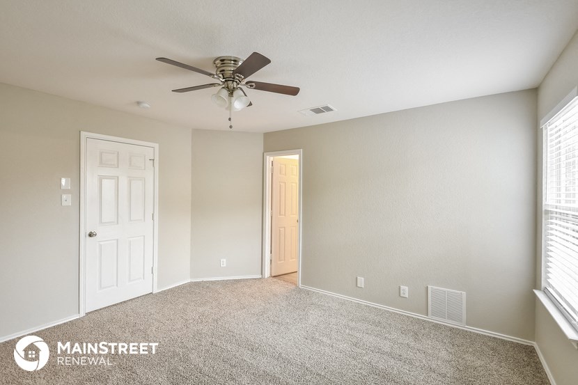 a bedroom with a ceiling fan and a white door