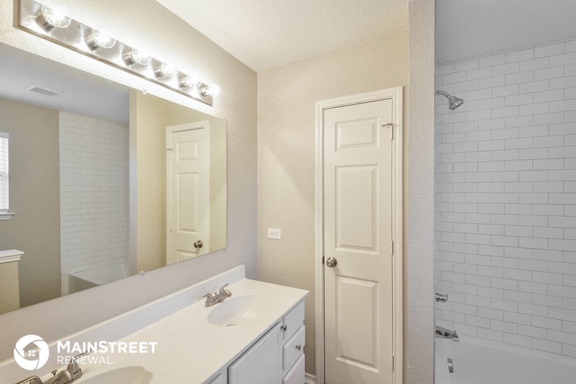 a white bathroom with a sink and a mirror