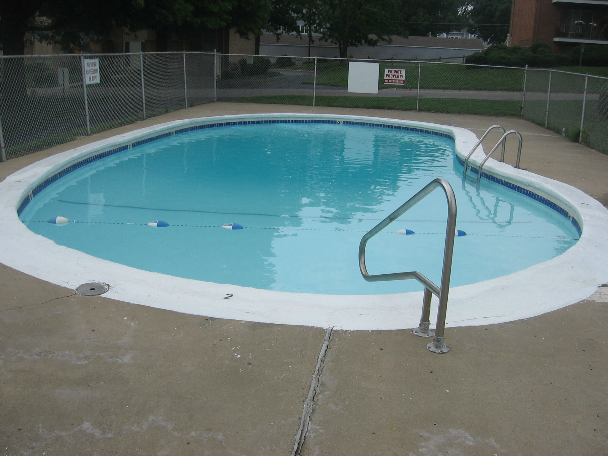 a swimming pool with a fence around it and a blue and white pool