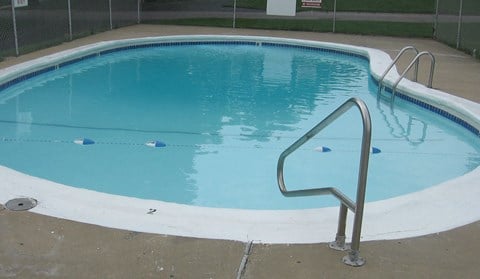 a swimming pool with a fence around it and a blue and white pool