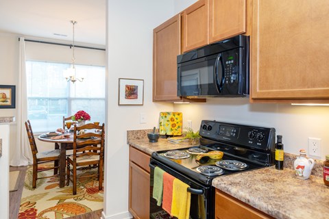 A kitchen with a black microwave above the stove.