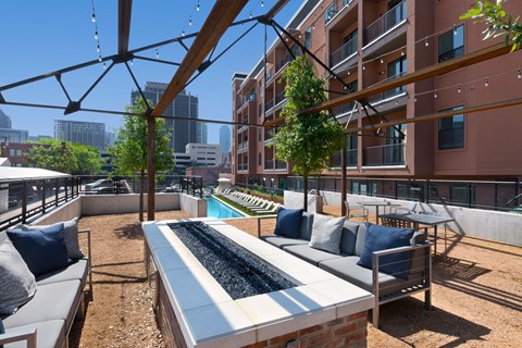 a lounge area with couches and a pool in front of a building