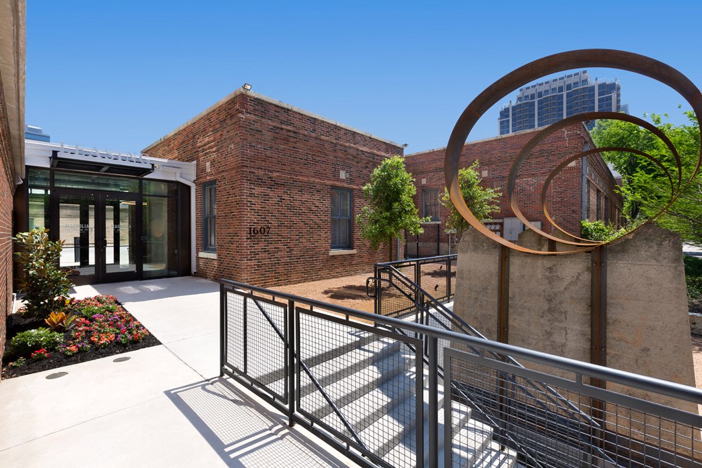 the courtyard of a building with a ramp and a sculpture of a circle