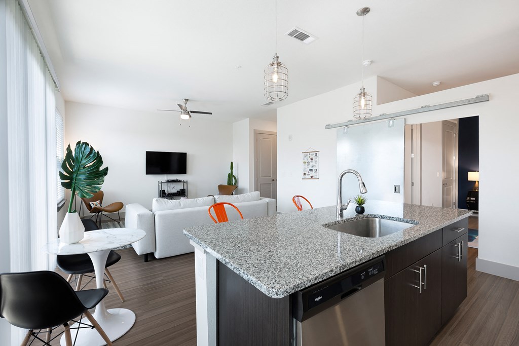 an open living room and kitchen with a granite counter top