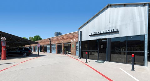 the outside of a fitness center with a car parked outside of it