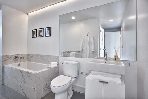 a white bathroom with a tub toilet and a sink