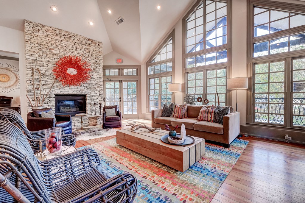 a spacious living room with a large stone fireplace and furniture