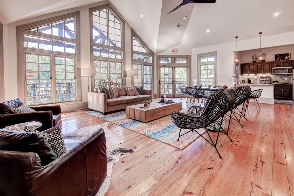 an open living room with a dining room and a kitchen with large windows