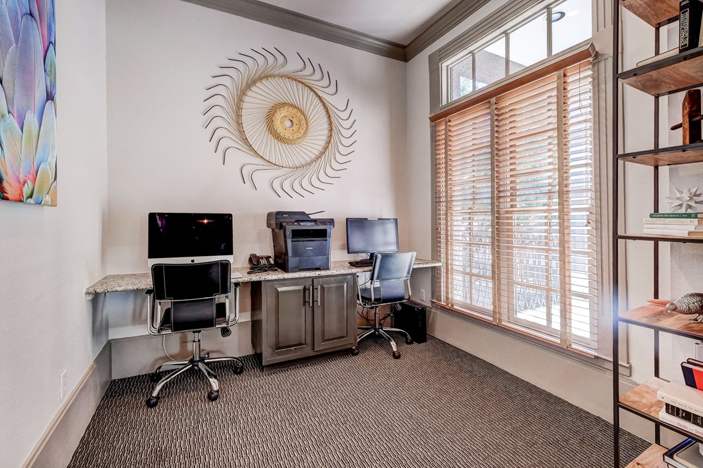 an office with two desks and two chairs and a window