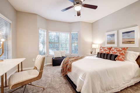 a bedroom with a large bed and a ceiling fan