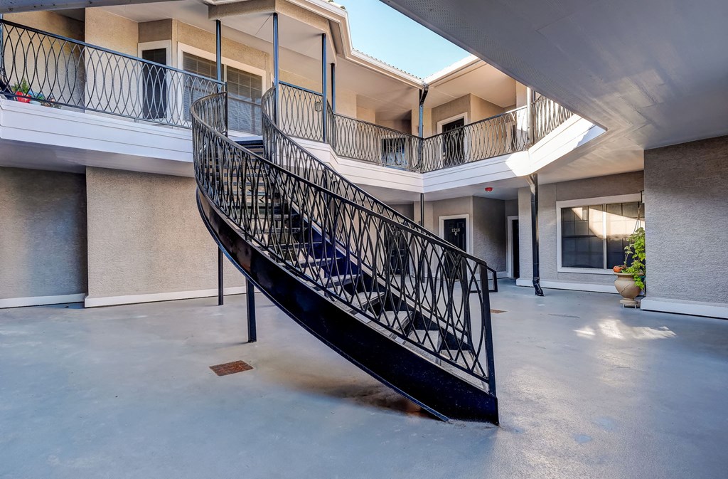 a spiral staircase with a black railing in a building