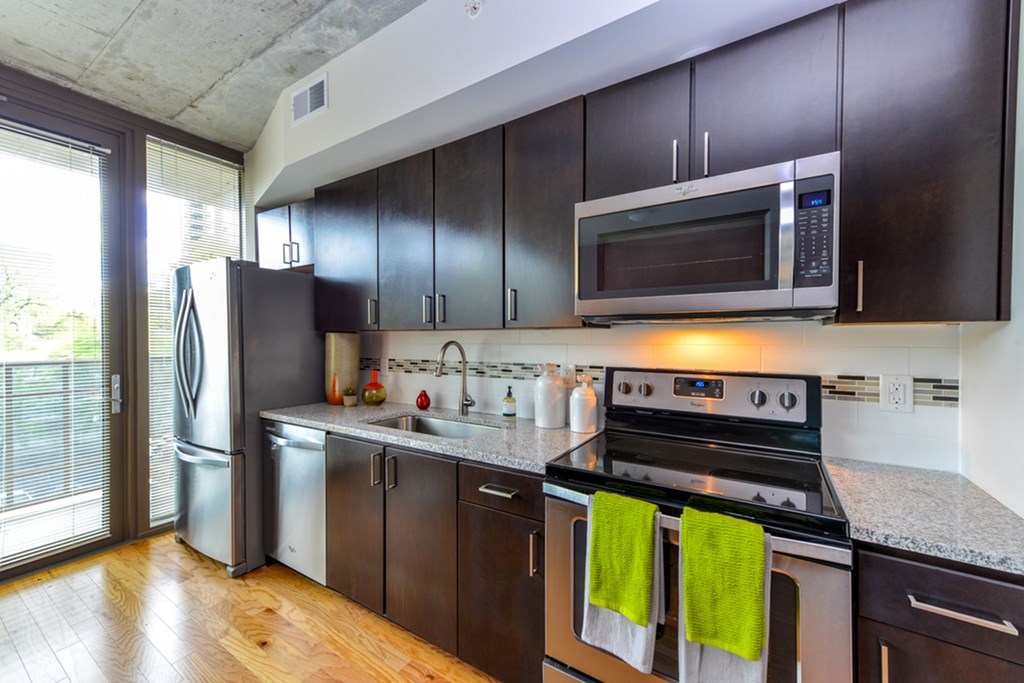 a kitchen with stainless steel appliances and dark wood cabinets
