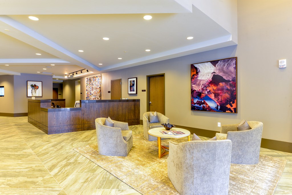 the lobby of a hotel with chairs and a reception desk