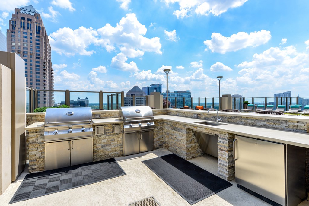 an outdoor kitchen with stainless steel appliances and city views
