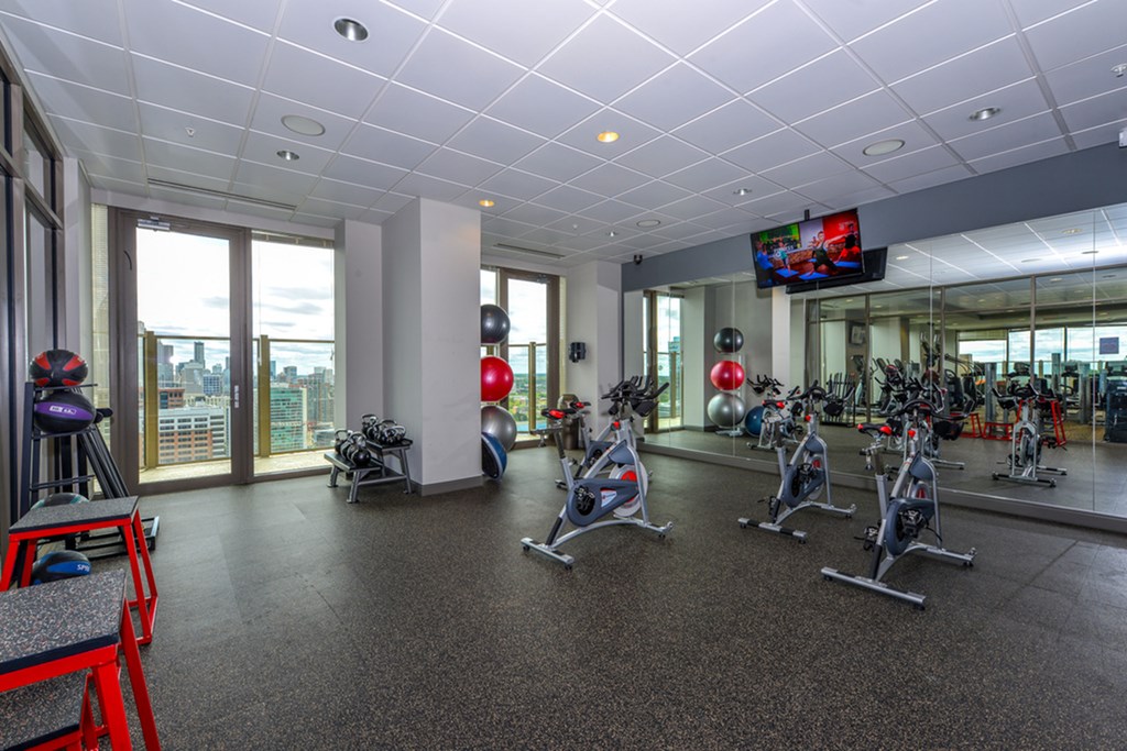 a gym with exercise bikes and other exercise equipment in a building with windows