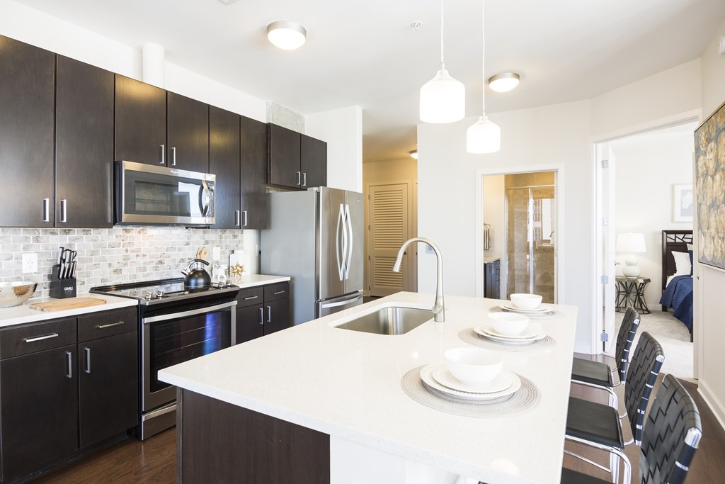 a kitchen with black cabinets and a white counter top and a sink
