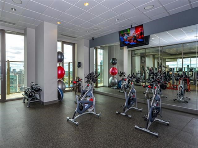 a gym with a bunch of exercise bikes and a tv