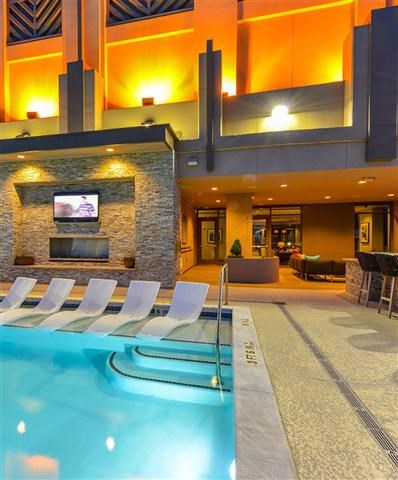 a swimming pool with chairs and a fireplace