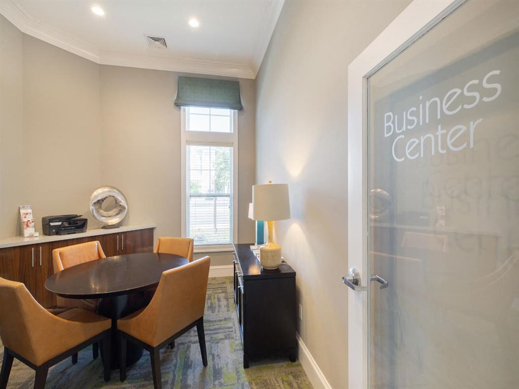 a dining room with a table and chairs in front of a business center door