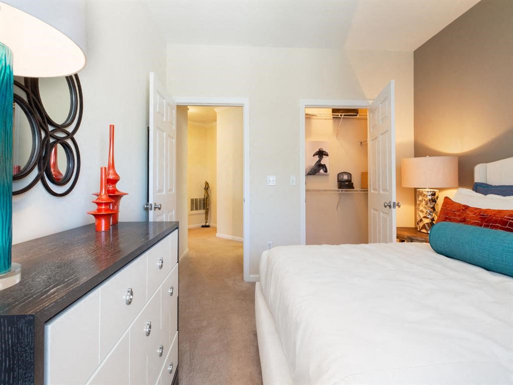 a bedroom with a white bed and a closet