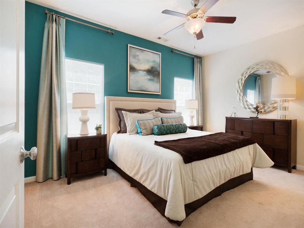 a bedroom with a bed and a ceiling fan