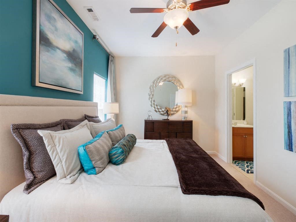 a bedroom with a large bed and a ceiling fan