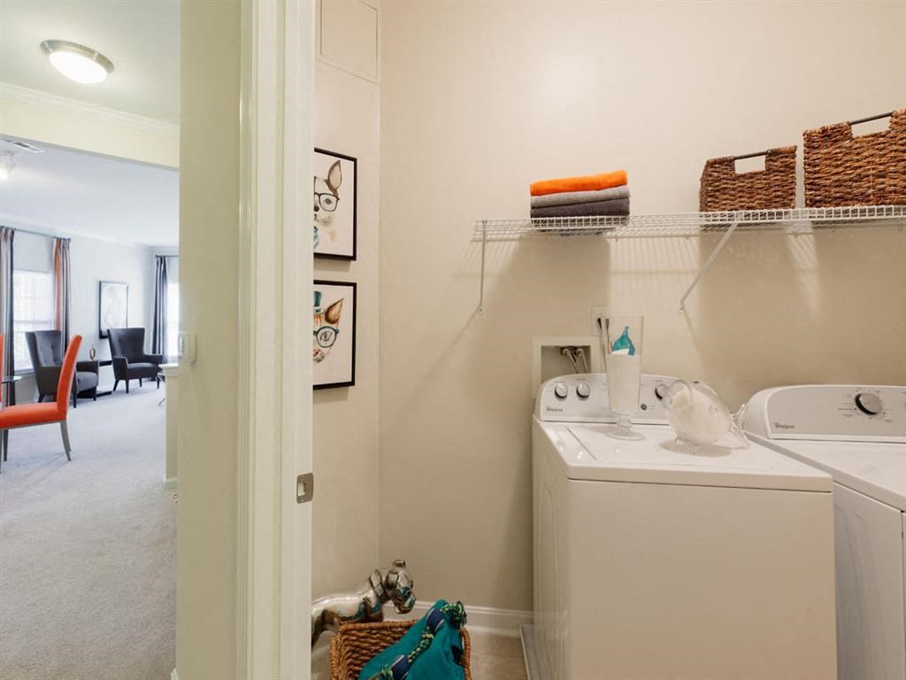 a washer and dryer in a small laundry room next to a sink