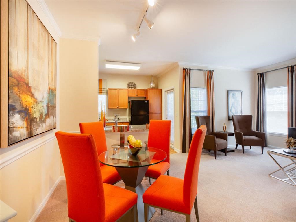 a living room and dining room with a table and chairs