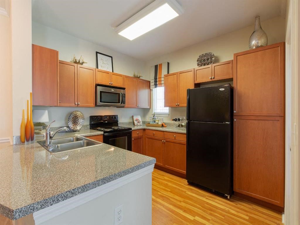 a kitchen with a granite counter top and a black refrigerator