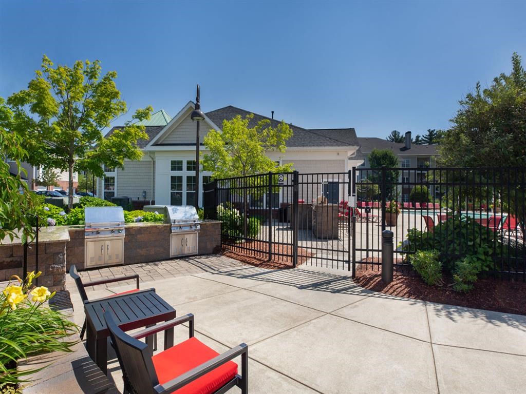 a patio with a table and chairs in front of a house